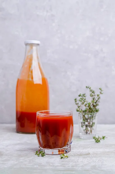 Thick red vegetable juice in glass on a light background. Selective focus.