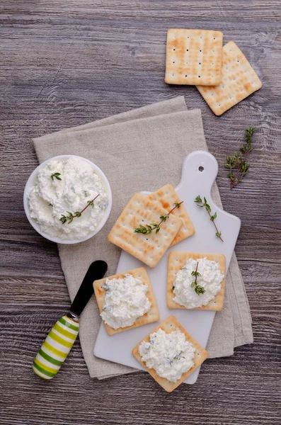 Tahta zemin üzerinde kekik ve kraker olan geleneksel yumuşak peynir. Seçici odak.