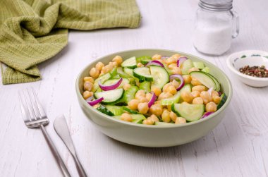 Ahşap bir arka planda nohutlu çiğ sebze salatası. Seçici odak.