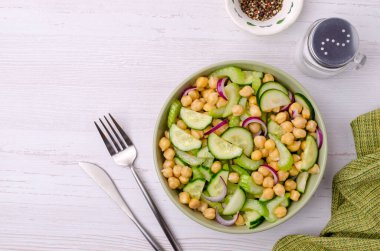 Ahşap bir arka planda nohutlu çiğ sebze salatası. Seçici odak.