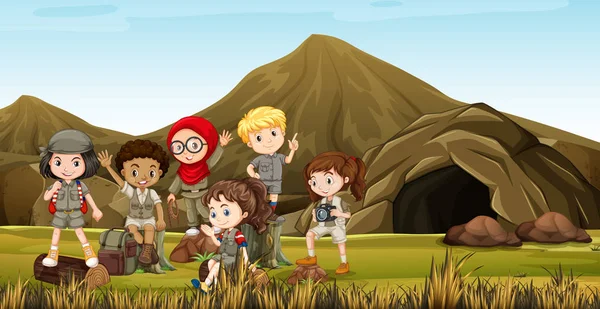 Niños en traje de safari acampando junto a la cueva — Vector de stock