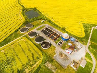 Aerial view to biogas plant from pig farm in green fields clipart