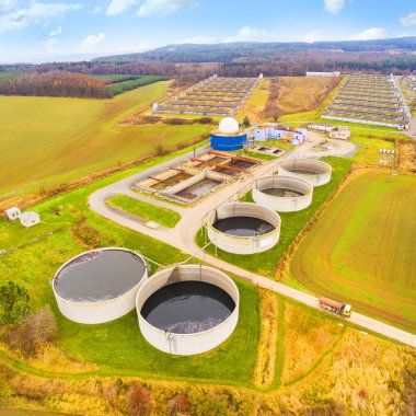 Aerial view to biogas plant from pig farm in green fields clipart