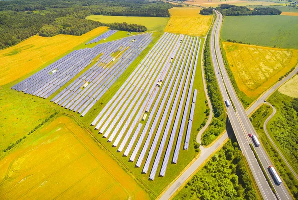 Εναέρια άποψη για την ηλιακή μονάδα παραγωγής ενέργειας κοντά στον αυτοκινητόδρομο με κίνηση — Φωτογραφία Αρχείου