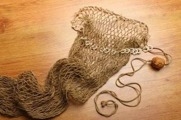 Fishing net with cork buoy on wooden plate — Stock Photo, Image