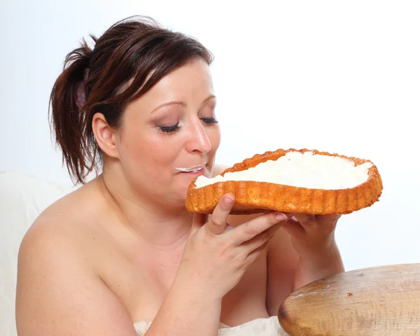 Overweight woman eating sweet cream cake — Stock Photo, Image