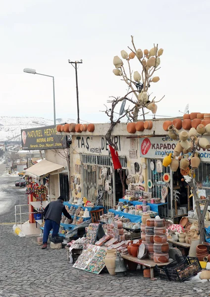 Tendero no identificado haciendo regalos listos para los turistas en frente de la tienda de regalos — Foto de Stock