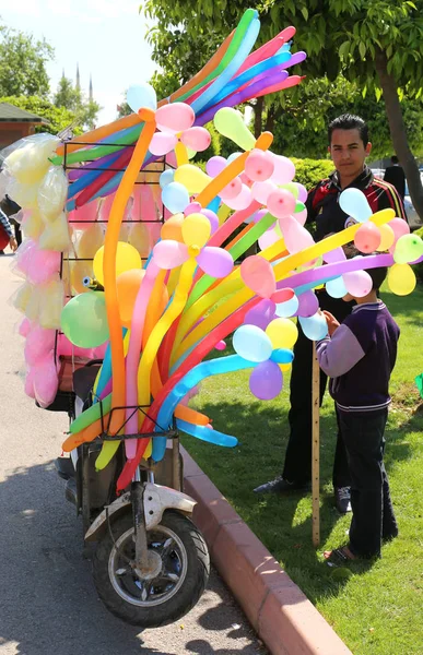 Ragazzo che vende caramelle colorate di cotone e palloncini su uno scooter al Carnevale dei Fiori d'Arancio — Foto Stock