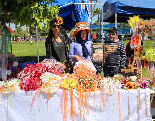 正体不明の女性とオレンジの花のカーニバルでポーズの塗られた表面を持つ少年 — ストック写真