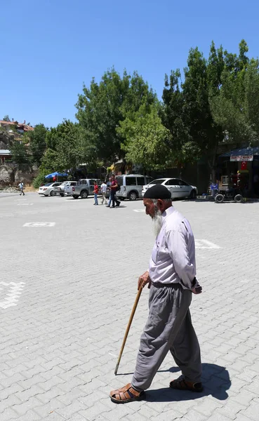 Unidentified Old Man with long beard and cane walking in the village square — Stock Photo, Image