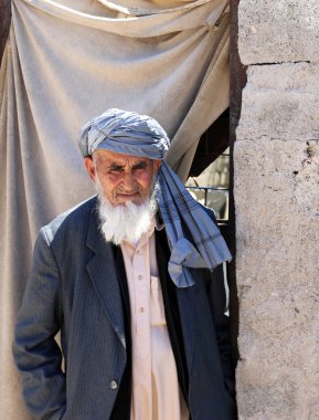 Ayakta ve evinin önünde poz uzun sakallı dini Afgan adam