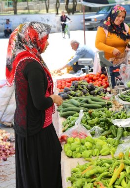 Kimliği belirsiz bir kadın çiftçi pazar sebze satın Hijab ile