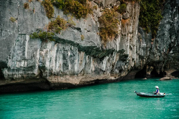 Güney Çin Denizi 'nin Ha Long Körfezi' ndeki kayaların ve yerel balıkçı teknesinin manzarası. Ha Long Körfezi Asya 'nın popüler bir turizm merkezidir..