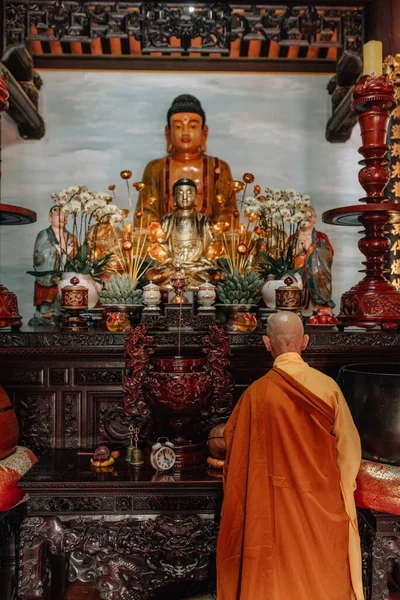 Tam Coc, Vietnam 'daki Bi nh Tapınağında altın bir Buda önünde dua eden Budist keşiş