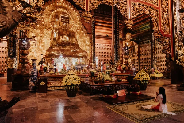 Fille Bouddhiste Priant Devant Bouddha Doré Dans Temple Tam Coc Photo De Stock