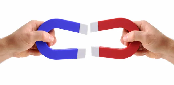 Hands holding magnets one red and one blue — Stock Photo, Image