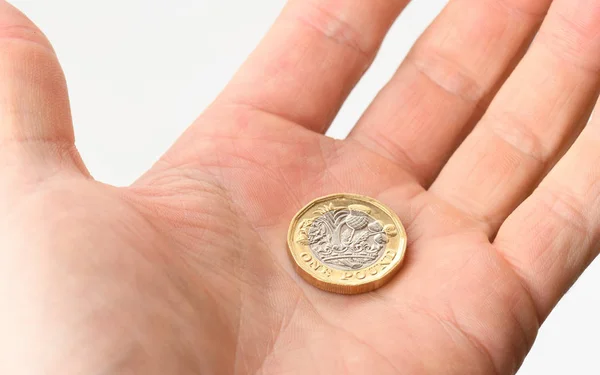 A hand open offering a pound coin — Stock Photo, Image