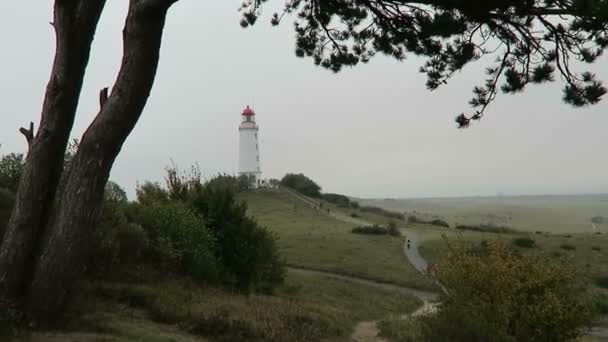 People hiking to Lighthouse on Dornbusch hill in Hiddensee Isle in Germany. Autumn time. — Stock Video