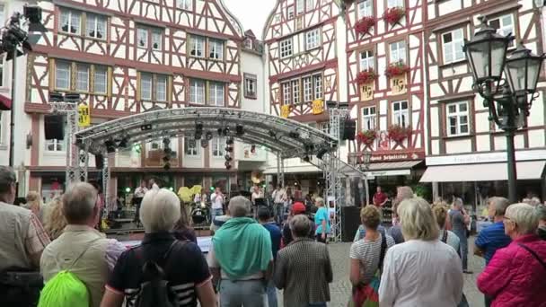 Pessoas que visitam o festival do vinho em Bernkastel, no rio Moselle. banda de música dando concerto no mercado local . — Vídeo de Stock