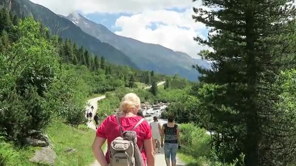 Personas que visitan las cascadas de Krimml, haciendo senderismo a lo largo del sendero a las cataratas y en el valle achental. Austria . — Vídeo de stock