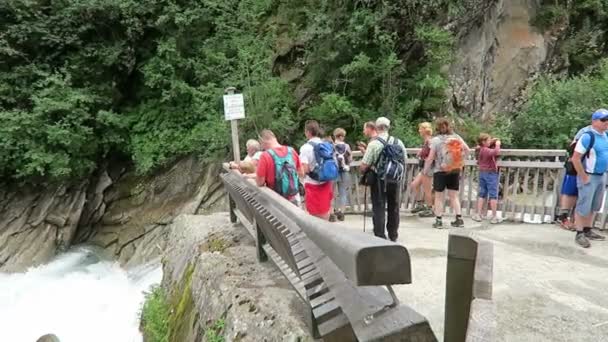 Personer som besöker vattenfallen Krimml, vandring längs vandringsleden till falls. Österrike. — Stockvideo