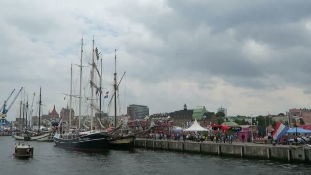 ROSTOCK, Meclemburgo-Pomerania Anteriore / GERMANIA 13 AGOSTO 2016: barche a vela storiche e goletta che navigano lungo il porto di Rostock a Warnemuende durante l'evento Hanse Sail weekend . — Video Stock