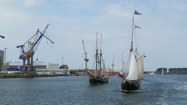 WARNEMUENDE, Mecklenburg-Vorpommern/ GERMANY AUGUST 13 2016: historical sailing boats and schooner sailing along the Rostock Harbor at Warnemuende during Hanse Sail weekend event. — Stock Video