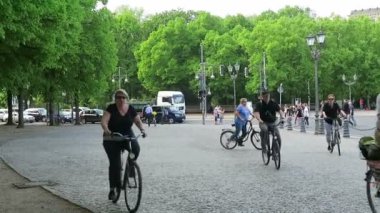  İnsanlar şehirde Berlin bisikletle sürme. arka plan reichstag ve Brandenburger tor.
