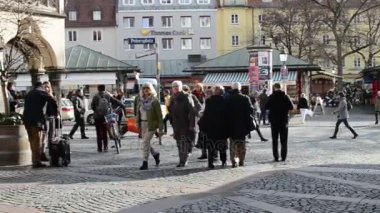 Münih'te Viktualienmarkt üzerinde yürüyen insanlar.