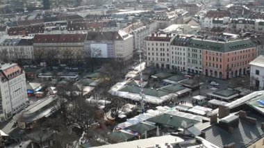 Münih'te Viktualienmarkt üzerinde yürüyen insanlar. Sonbahar zaman. Küçük Mağazalar ve tezgahları. St. Peter Kilise havadan görünümü.