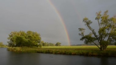 Havel Nehri boyunca bir tekne ile sürüş. Gökkuşağı (Brandenburg, Almanya) ile yağmur. Havelland.