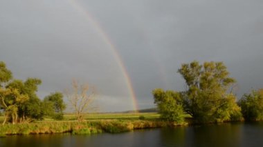 Havel Nehri boyunca bir tekne ile sürüş. Gökkuşağı (Brandenburg, Almanya) ile yağmur. Havelland.