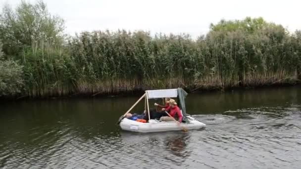 Люди в маленькой белой лодке проплывают мимо. вождение с кораблем вдоль реки Гавел. типичный пейзаж с лугами и ивами. Регион Хафелланд. (Германия ) — стоковое видео