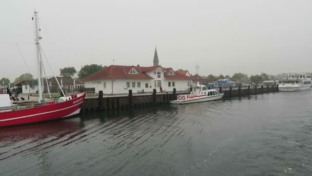 Schaprode, Mecklenburg-Vorpommern/ GERMANY October 19 2016: leaving the harbor of Schaprode with a ferry. Passing by boats and promenade. — Stock Video