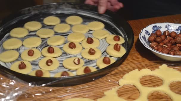 Decorating the raw cookies with hazelnuts. — Stock Video