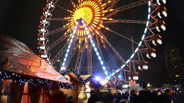 Personas que visitan la feria de Navidad en alexanderplatz en Berlín (Alemania). en puestos del mercado delantero con alimentos y artículos artesanales. rueda de los transbordadores en fondo — Vídeo de stock