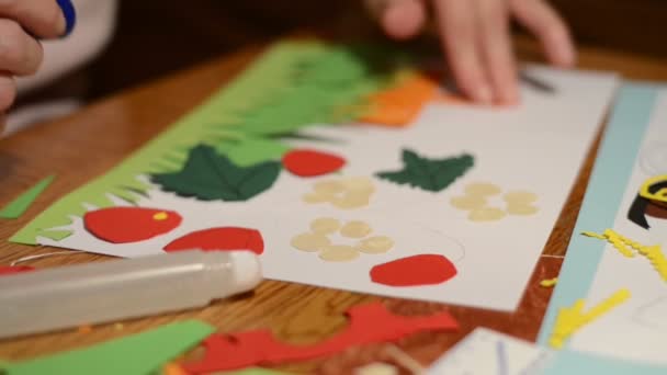 К ремеслу. сортировка листьев клубники, фруктов и цветочных головок картонной бумаги для клея . — стоковое видео