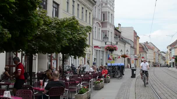 Stadtbild von brandenburg an der havel. die Hauptstraße mit Straßenbahngleisen, kleinen Cafés und Geschäften. Menschen laufen durch die Innenstadt. — Stockvideo