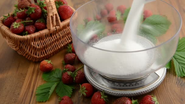 Erdbeeren in kleinem Korb. Schüssel auf der Gewichtswaage mit Zucker füllen. Blatt und Blütenkopf auf einem Holztisch. Marmelade kochen. — Stockvideo