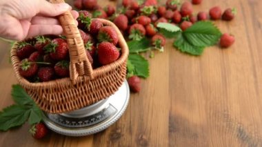 yaprak ve çiçek ahşap masa üzerinde kafa ile ağırlık ölçekte çilek sepeti. reçel yapımı.