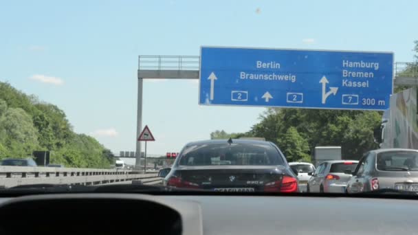 De jam van het verkeer op de snelweg A2 (Duitsland). Richting teken voor Berlijn bovenop. Auto rijden langzaam vooruit. — Stockvideo