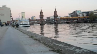 Berlin. Doğu Yakası Galerisi, sahil boyunca yürüyüş insanlar. arka planda Oberbaumbruecke