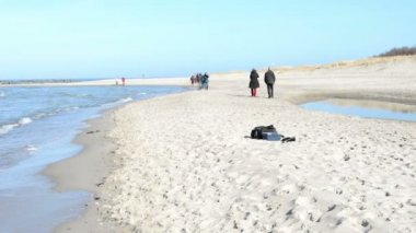 İnsanlar Darss yarımadalar (Mecklenburg-Vorpommern, Germany) adlı Ahrenshoop köy, Baltık Denizi plajda yürüyorduk. Sağ tarafta tipik kum tepeleri üzerinde.