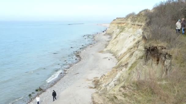 People walking along at the Baltic Sea beach of village  Wustrow at Darss peninsulas (Mecklenburg-Vorpommern, Germany). On right side typical sand dunes. — Stock Video