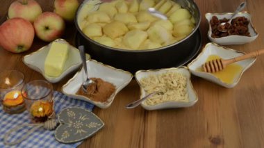 Elmalı pasta pişirme. Ham elma pasta şekeri serpilir. Ayrıca, bal, tarçın, şeker, badem slivers gibi maddeler vardır