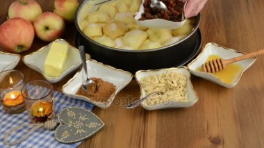 Elmalı pasta pişirme. Ham elma pasta üzerine serpilir kuru üzüm. Ayrıca, bal, tarçın, şeker, badem slivers gibi maddeler vardır