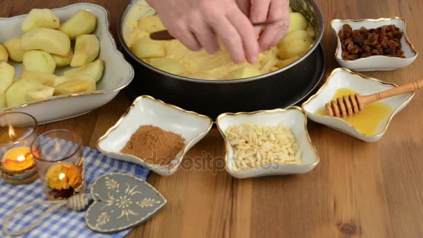 Pastel de manzana horneado. Esparciendo rodajas de manzana en la masa de pastel. Además, ingredientes como miel, canela, azúcar, astillas de almendras — Vídeo de stock