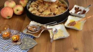 Elmalı pasta pişirme. Ham elma pasta üzerine serpilir tereyağı pul. Ayrıca, bal, tarçın, badem slivers gibi maddeler vardır