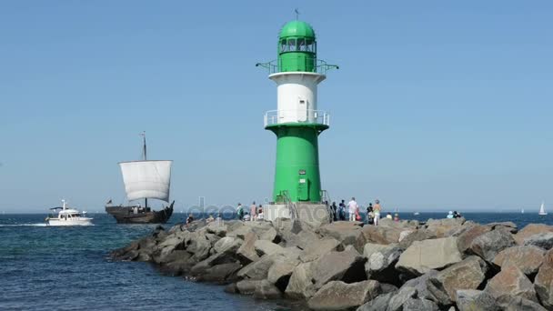 人们走到瓦尔内明德的灯塔。一个齿轮和一艘汽船骑从波罗的海到端口. — 图库视频影像