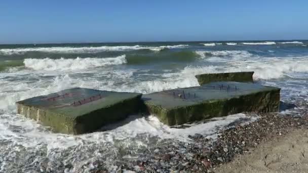 Strand van de Oostzee kust bij Wustrow. oude bunker van de Tweede Wereldoorlog in golven. — Stockvideo
